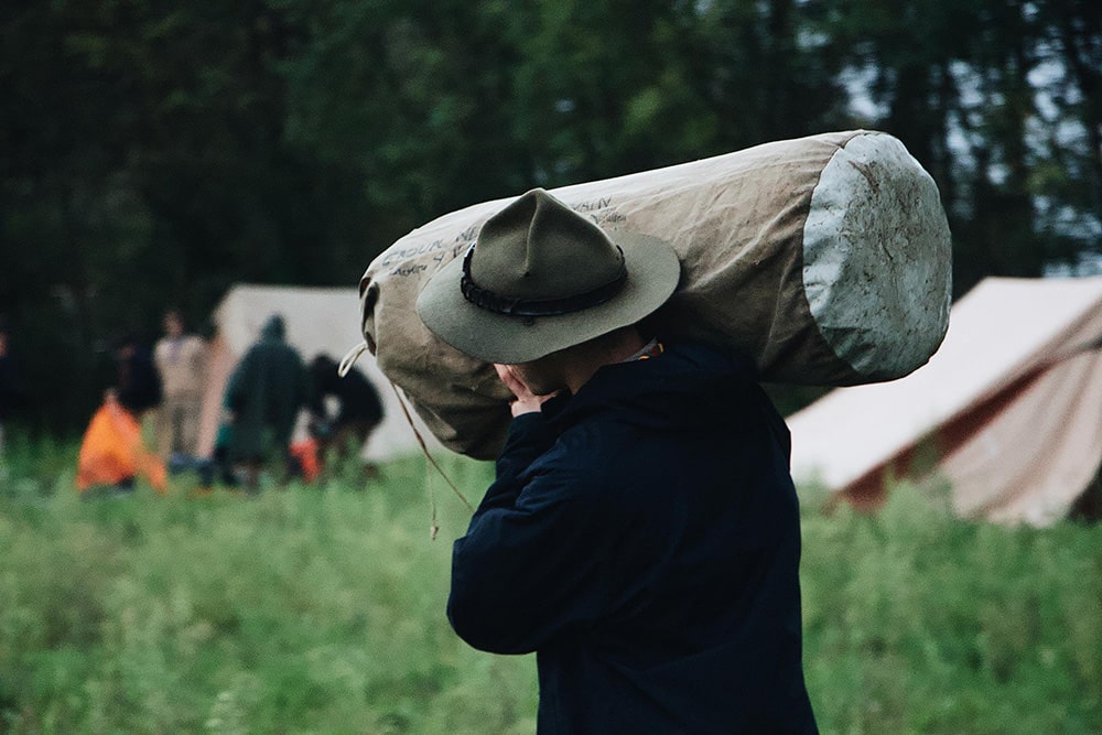 man carrying a sleeping bag on his sholder